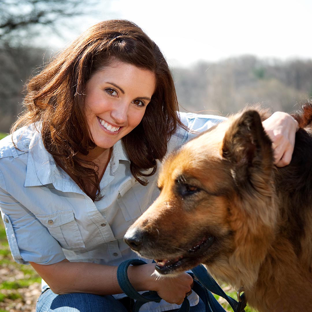 Smiling woman petting dog